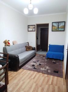 a living room with a couch and a blue cushion at Apartment in Tbilisi City