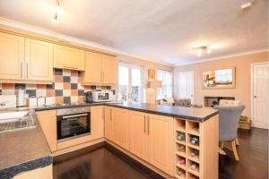 a kitchen with yellow cabinets and a black counter top at Lovely and Modern Three Bedroom House in Durham in Durham