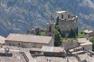 an old castle in the middle of a town with roofs at Greolières: Superbe Studio avec vue montagne in Gréolières