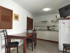 a kitchen with a table and chairs and a refrigerator at El Fraile in Tejeda