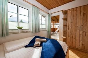 ein Schlafzimmer mit einem Bett mit einer blauen Decke darauf in der Unterkunft Chalet Gletschermoos in Zell am See