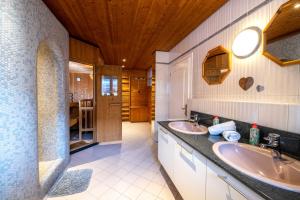 a bathroom with two sinks and a wooden ceiling at Chalet Gletschermoos in Zell am See