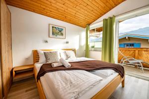 ein Schlafzimmer mit einem Bett und einem großen Fenster in der Unterkunft Chalet Gletschermoos - Summer Card included in Zell am See