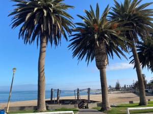 dos palmeras y un parque infantil en la playa en Ocean view, Swakopmund, 3-bedroomed apartment, en Swakopmund