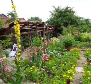 einen Garten mit bunten Blumen und einer Holzkonstruktion in der Unterkunft Ferienwohnung Kuschel in Thanstein