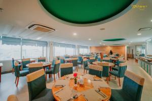 ein Restaurant mit Tischen und Stühlen und einer grünen Decke in der Unterkunft Romance Hotel in Hue