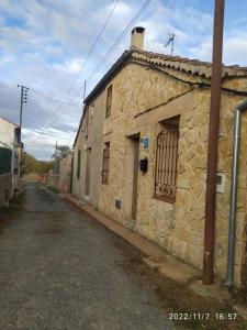 un antiguo edificio de piedra con una puerta en una calle en Casa Rural Hoces del Duratón El Villar Sepúlveda SEGOVIA, 
