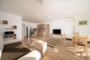 een keuken en een woonkamer met een tafel en stoelen bij Moana Fishermen Apartment in Ahtopol