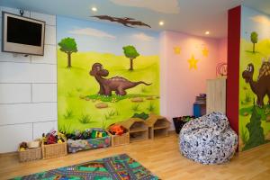 a childs room with a dinosaur mural on the wall at Parkhotel Waldlust in Häusern