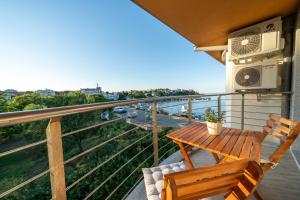a balcony with a table and a microwave at Moana Fishermen Apartment in Ahtopol