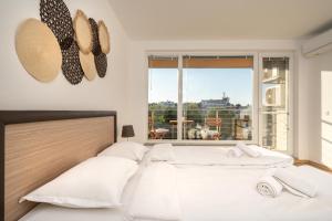 a bedroom with two beds and a large window at Moana Fishermen Apartment in Ahtopol