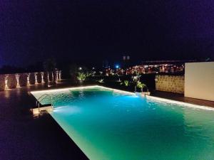 a swimming pool at night with a city in the background at Nirvana Resort and Restaurant in Garudeshwar