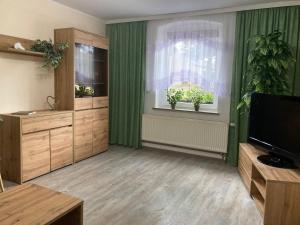 a living room with green curtains and a window at Ferienwohnung Fam. Natusch in Steinhöfel