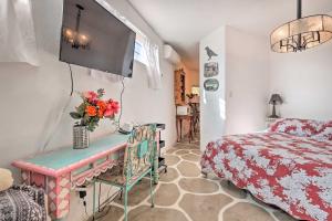 a bedroom with a bed and a desk with flowers on it at Quirky Santa Cruz Studio with Shared Hot Tub! in Santa Cruz