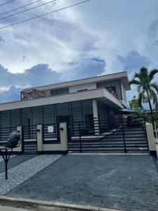 a building with stairs and a palm tree in front of it at Casa Alta Gracia in Paramaribo