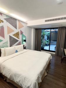 sypialnia z dużym białym łóżkiem i dużym oknem w obiekcie Innk w mieście Taizhong