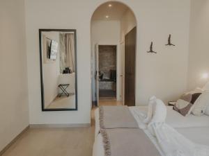 a white bedroom with a bed and a mirror at Comfy Studios in Benalmádena