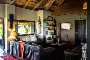 a living room with a leather couch and a table at Ezulwini Game Lodges in Balule Game Reserve
