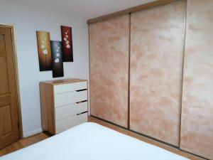 a bedroom with a bed and a wooden cabinet at Beautiful and peaceful large double bedroom near Olympic Park in Stratford London in London