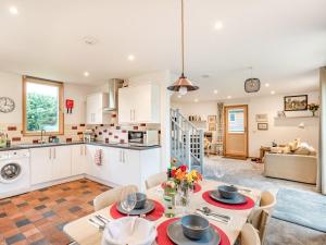 a kitchen and living room with a table and chairs at Brindleshaw Barn in Meopham
