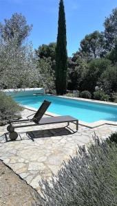 una piscina con 2 tumbonas junto a ella en Villa séduisante et charmante, en Castillon-du-Gard