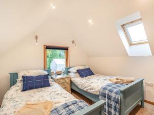 2 Einzelbetten in einem Zimmer mit Fenster in der Unterkunft Brindleshaw Barn in Meopham