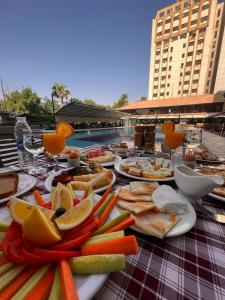 une table avec des assiettes de nourriture sur une table dans l'établissement فندق بغداد Baghdad International Hotel, à Bagdad