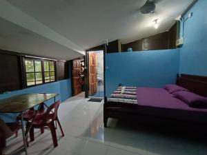 um quarto com uma cama e uma mesa num quarto em Homestay Koperasi Surau Alfalah em Semporna