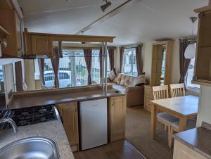 a kitchen and living room of a caravan at Park Home at Lyons Winkups Holiday Park N.Wales in Kinmel Bay