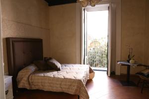 a bedroom with a bed and a large window at Albergo Del Centro Storico in Salerno