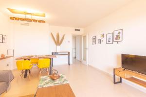 een woonkamer met een tafel en gele stoelen bij Ambar Beach in Calpe