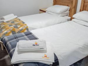 two beds with white towels on top of them at Ship Ahoy in Walcott