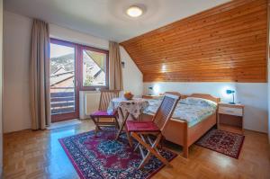 a bedroom with a bed and a table and chairs at Guest House Alenka in Bohinj