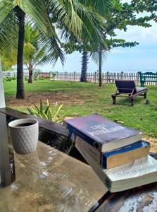 una pila de libros sobre una mesa en Pearl Oceanic Resort - Trincomalee, en Trincomalee