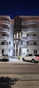 two cars parked in front of a building at night at Villa Alba Apartments in Dobra Voda