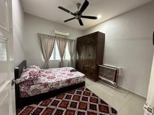 a bedroom with a bed and a ceiling fan at D'beeba Homestay in Pedas
