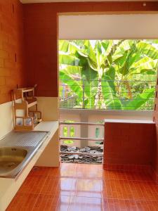 a bathroom with a large window and a sink at Bunraksa Resort in Kamphaeng Phet