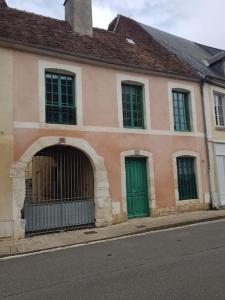 un edificio rosa con puertas verdes en una calle en Le petit Conté - Maison calme en centre ville, en Sées