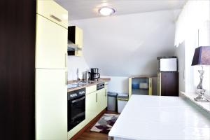 uma cozinha com um balcão branco e um frigorífico em Haus-Magarethe em Detern