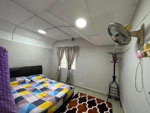 a bedroom with a bed and a fan at D'beeba Homestay in Pedas