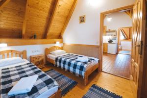 two beds in a room with a kitchen at Kormorán Vendégház in Tiszafüred