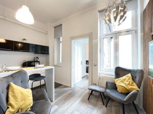 een keuken en een woonkamer met 2 stoelen en een tafel bij Agape Apartments in Zagreb