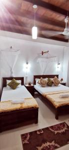 two beds in a bedroom with two rugs at Comfort Inn- Galle Fort in Galle