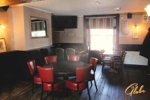 a dining room with a table and red chairs at The Globe Inn in Tiverton