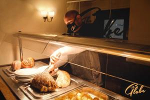 un hombre está preparando comida en una cocina en The Globe Inn en Tiverton