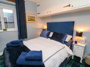 a bedroom with a large bed with blue pillows at Moor Cottage in Carnforth