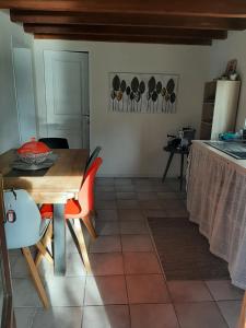 eine Küche mit einem Holztisch sowie einem Tisch und Stühlen in der Unterkunft Gîte à la campagne avec piscine in Biziat
