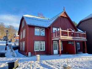 a red house with a deck in the snow at Åre Travel - Åre Park in Åre