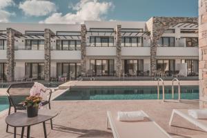 a hotel with a swimming pool and a building at CAVO SUITES in Kalamaki