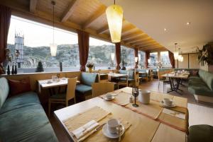 un restaurante con mesas, sillas y ventanas grandes en Schönblick - Gurgl, en Obergurgl